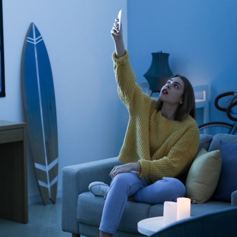 Het is een vrouw die geërgerd naar haar telefoon kijkt, thuis